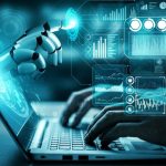 Robotic hand reaches from holographic screens above a laptop, depicting AI and data analytics.